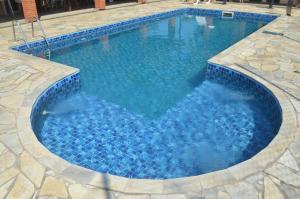 duży basen z niebieską wodą w obiekcie Sítio Oliveira w mieście Itariri