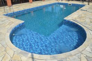 a large swimming pool with blue water at Sítio Oliveira in Itariri