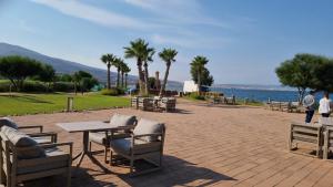 a patio with tables and chairs next to the water at شقة الكرنيش in Nador
