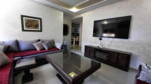 a living room with a couch and a flat screen tv at شقة الكرنيش in Nador