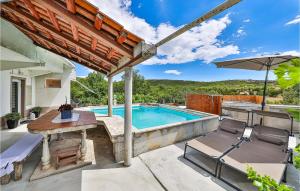 a patio with a table and chairs and a swimming pool at Cozy Apartment In Labin With Wifi in Labin