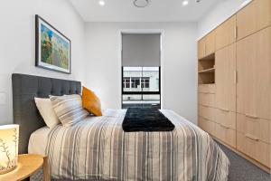 a bedroom with a large bed and a wooden cabinet at Academy Apartments in Masterton