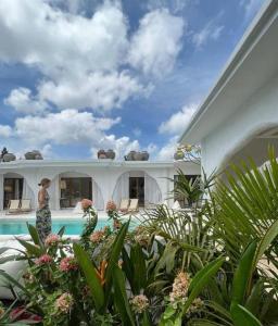a woman standing in front of a house with a swimming pool at Sal Central in Uluwatu