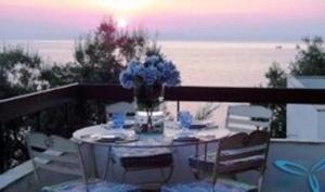 a table with chairs and a vase of flowers on a balcony at Sea Front in Milina