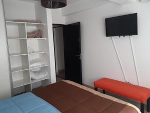 a bedroom with a bed and a red bench and a tv at Departamentos Giovanni in Salta