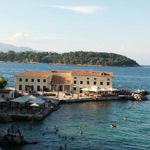 een groep mensen in het water in een resort bij Eftihia di corfu in Corfu-stad