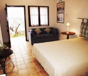 a bedroom with a bed and a couch in a room at Sea Front in Milina