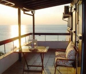 a balcony with a table and chairs and the ocean at Sea Front in Milina