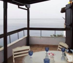 a table on a balcony with a view of the ocean at Sea Front in Milina
