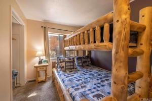 1 dormitorio con litera y escalera en The Winding Cabin-HOT TUB!GAME ROOM! MOUNTAINSIDE!, en Big Bear City