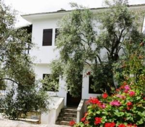 a white house with some flowers in front of it at Sea Front in Milina