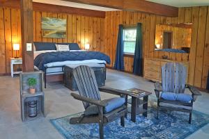 a bedroom with a bed and a desk and chairs at St Lawrence River Retreat in Ogdensburg