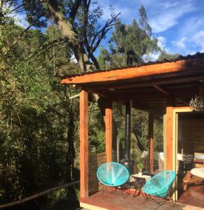 2 sillas y una mesa en una terraza en Acogedora cabaña en el bosque, Via La Calera, en La Calera