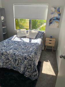 een slaapkamer met een bed en een groot raam bij Sunny Sandringham SkyTower Views Close to City in Auckland