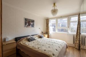 a bedroom with a bed and a large window at 1 Bedroom Flat Close to City with Free Parking Arrangement in London
