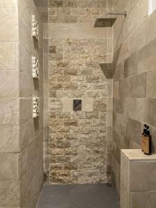 a bathroom with a stone wall and a shower at Green Banana in Gili Trawangan