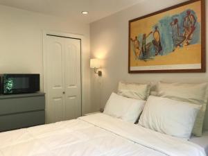 - une chambre avec un lit blanc et une télévision dans l'établissement Holland Villa Vancouver, à New Westminster