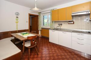 cocina con armarios blancos y mesa de madera en Schoenblick, en Chiusa