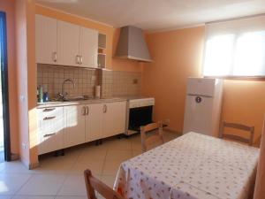 a kitchen with a table and a white refrigerator at Villa Lilly in Prima Porta