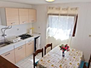 uma cozinha com uma mesa com um vaso de flores em Apartments and rooms by the sea Stara Novalja, Pag - 11626 em Novalja