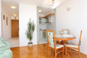 kuchnia i jadalnia ze stołem i krzesłami w obiekcie Holiday apartments Split - 11638 w Splicie