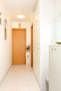 przedpokój z drewnianymi drzwiami i białą podłogą wyłożoną kafelkami w obiekcie Holiday apartments Split - 11638 w Splicie
