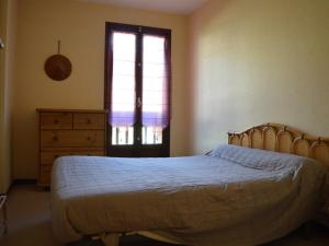 1 dormitorio con cama, ventana y vestidor en Appartement Les Angles, 2 pièces, 4 personnes - FR-1-593-48, en Les Angles