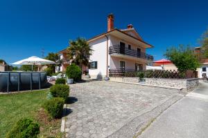 a large white house with a driveway at Family-friendly apartments with swimming pool Cepic, Central Istria - Sredisnja Istra - 11636 in Zatka Čepić