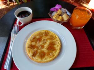 a white plate with a pancake on a table at Nika's House in Siem Reap