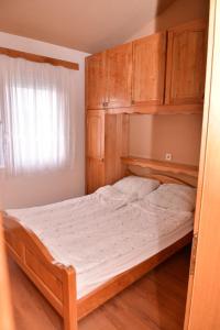 a bed in a bedroom with wooden cabinets at Apartments with a parking space Stinjan, Pula - 11648 in Štinjan