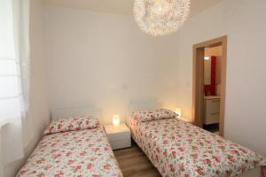 two beds in a bedroom with a chandelier at Holiday house with a parking space Premantura, Medulin - 11631 in Premantura