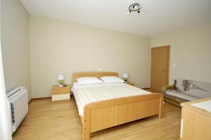 a bedroom with a wooden bed and a couch at Apartments with a parking space Plano, Trogir - 11649 in Trogir