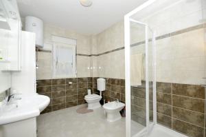 a bathroom with a toilet and a sink and a shower at Apartments with a parking space Plano, Trogir - 11649 in Trogir