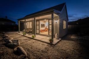 una pequeña casa con puertas de cristal en un lateral en 2 Oaks Cottage Clyde en Clyde