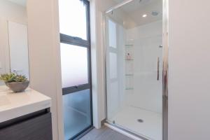 a bathroom with a glass shower stall and a sink at 2 Oaks Cottage Clyde in Clyde