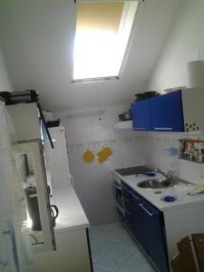 a small kitchen with a sink and blue cabinets at Apartments by the sea Sumartin, Brac - 11651 in Sumartin