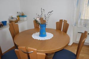 a dining room table with a blue vase on it at Apartments by the sea Sumartin, Brac - 11651 in Sumartin
