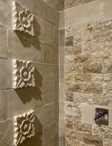 a bathroom with a stone wall with flowers on it at Green Banana in Gili Trawangan