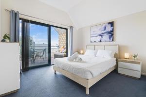a bedroom with a large bed and a balcony at All Decked Out, Geographe Marina in Busselton