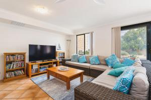a living room with a couch and a tv at All Decked Out, Geographe Marina in Busselton