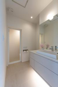 a bathroom with a large sink and a large mirror at Silver Maple Chalet by Hakuba White Fox Company in Hakuba