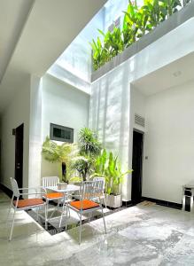 uma sala de jantar com mesa, cadeiras e plantas em HERA HOSTEL em Chau Doc