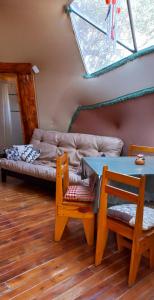 Domo Cielos del Uritorco في كابيلا ديل مونتي: غرفة معيشة مع طاولة وأريكة