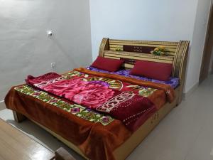 a bed with red pillows on top of it at WonderLand Guest House in Udhampur
