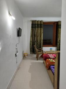 a room with a bed and a desk and a window at WonderLand Guest House in Udhampur