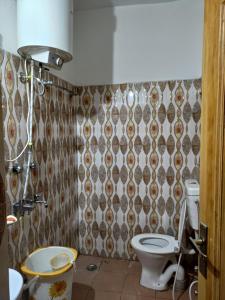 a bathroom with a toilet and a shower curtain at WonderLand Guest House in Udhampur