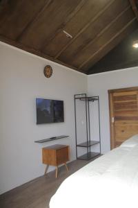 1 dormitorio con 1 cama y reloj en la pared en Teras Pahawang, en Sukojayo