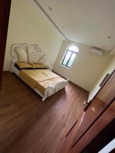 ein Schlafzimmer mit einem Bett in einem Zimmer mit einem Fenster in der Unterkunft Villas Little White House Quê Vải in Ðào Lãng