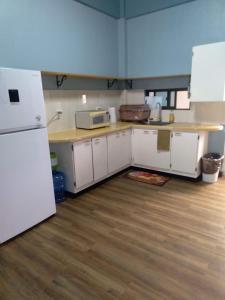 a kitchen with white cabinets and a white refrigerator at lee's home2 in San Vicente