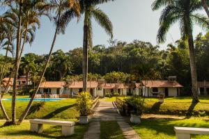 a resort with palm trees and a swimming pool at Pousada Tapera in Penedo